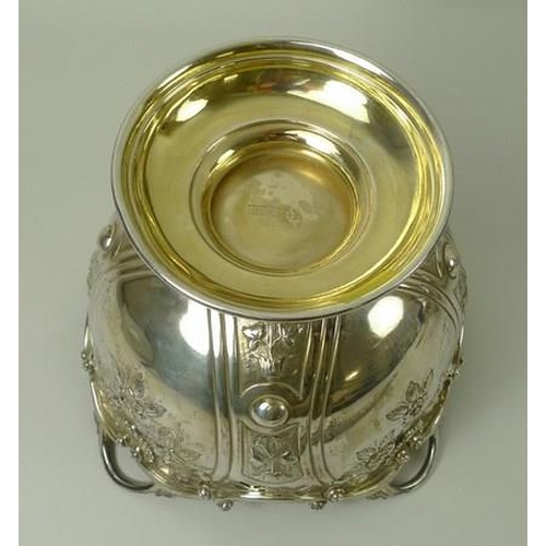 749 - A Victorian silver rose bowl, the embossed bowl with cast scrolled rim, gilt interior, raised on a d... 