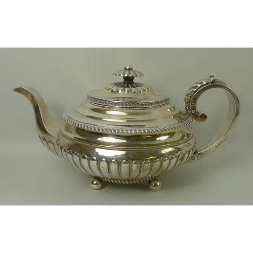 750 - A Scottish early 19th century silver teapot of squat form, decorated with gadrooned edges and part r... 