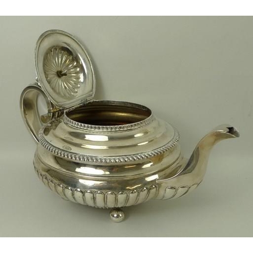 750 - A Scottish early 19th century silver teapot of squat form, decorated with gadrooned edges and part r... 