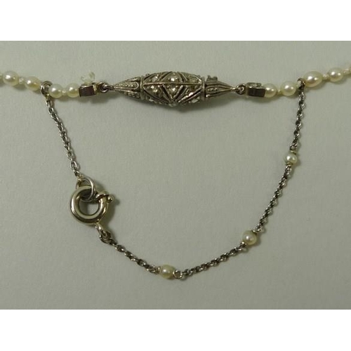 777 - An Edwardian Art Deco cultured pearl necklace, strung with graduating pearls, 1mm to 4mm, on a diamo... 