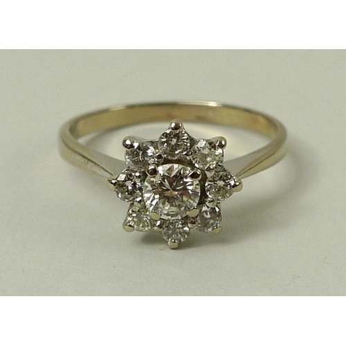 780 - An 18ct gold and diamond flower head ring, the central diamond of approximately 0.25ct with eight di... 