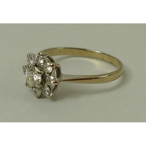 780 - An 18ct gold and diamond flower head ring, the central diamond of approximately 0.25ct with eight di... 