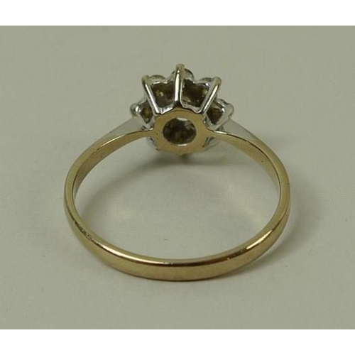 780 - An 18ct gold and diamond flower head ring, the central diamond of approximately 0.25ct with eight di... 