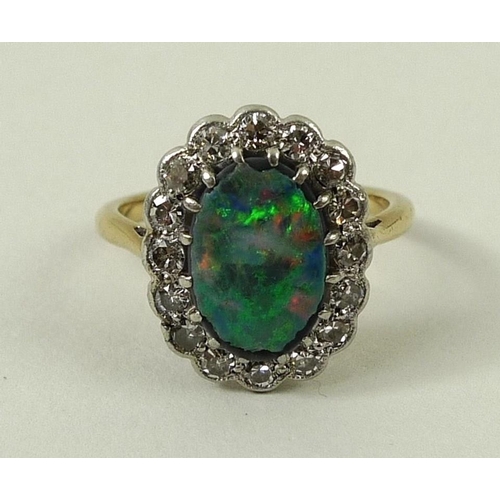 781 - An 18ct gold, opal and diamond ring, the central oval cut opal set in platinum and surrounded by six... 