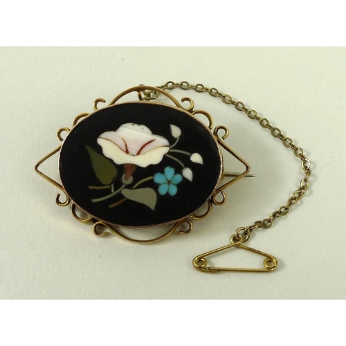 788 - An oval pietra dura brooch, the ground set with flowers and leaves, in 9ct gold scroll form mount, w... 