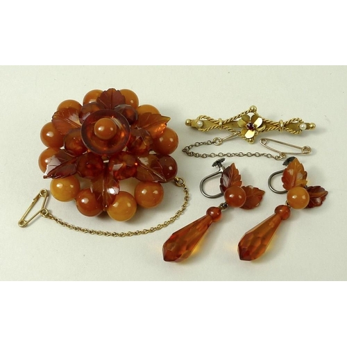 798 - An amber floral brooch, formed as three circles of stones divided by one ring of leaves, with safety... 