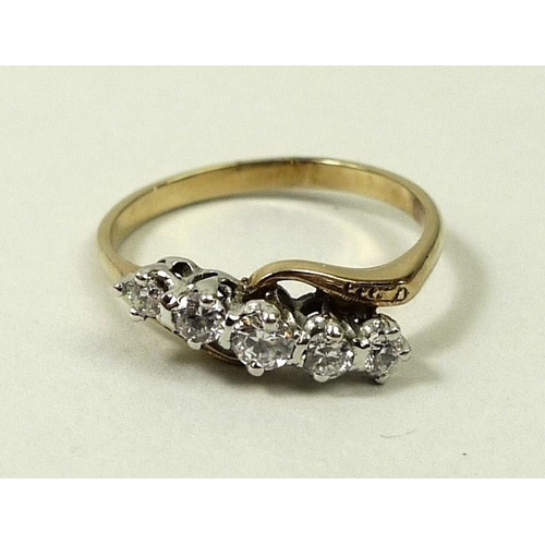 799 - An 18ct gold and diamond crossover ring, set with five graduated diamonds, total approximately 0.55c... 