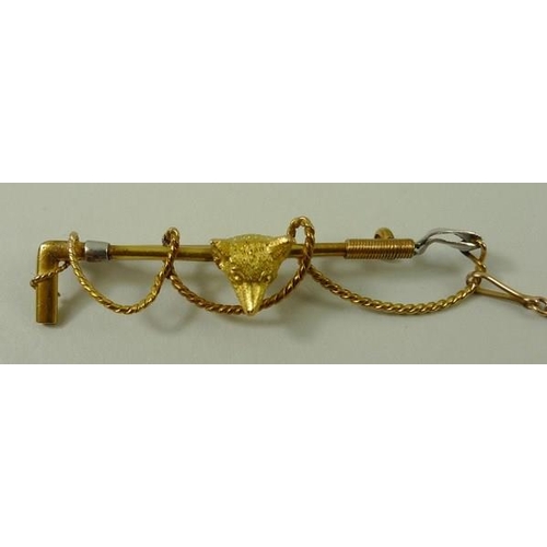 800 - A 15ct gold stick pin brooch, in the form of a hunting whip with fox's head, 7g total weight.