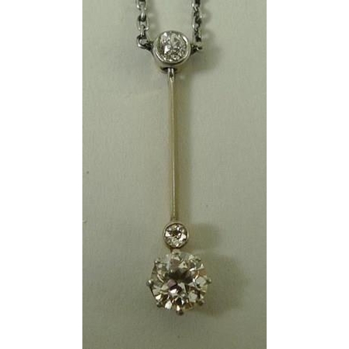 803 - An unmarked gold pendant necklace, set with a 0.5ct diamond on a slender bar, and two further smalle... 