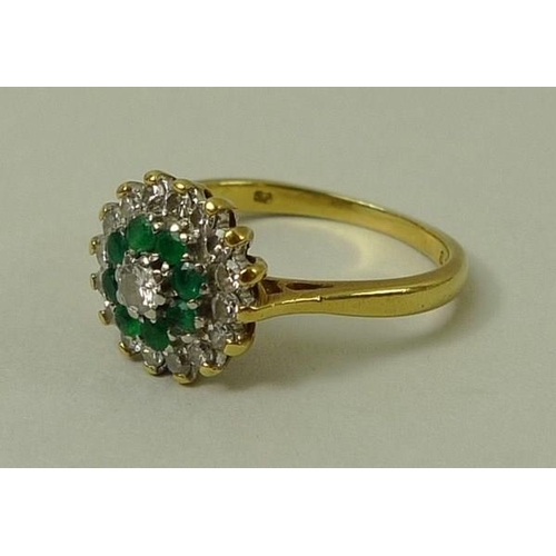 804 - An 18ct gold, diamond and emerald cluster ring, the central diamond of approximately 0.2ct encircled... 