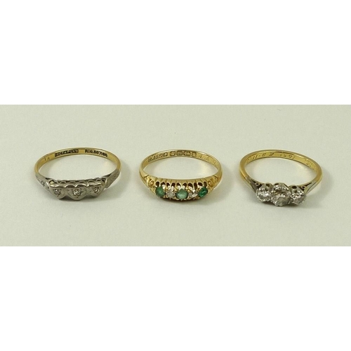 806 - An 18ct gold, diamond and emerald five stone ring, size N, an 18ct gold and diamond three stone ring... 