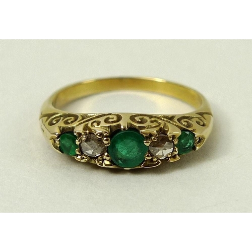 809 - An emerald and diamond five stone ring with three emeralds, interspersed with two diamonds within sc... 