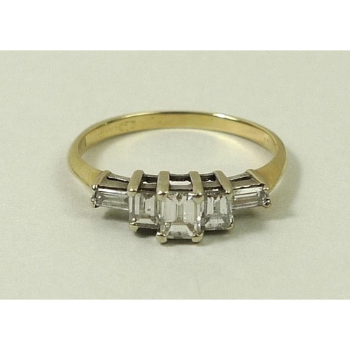 813 - A gold and diamond ring, the central baguette cut diamond flanked by two smaller diamonds, with two ... 