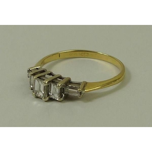 813 - A gold and diamond ring, the central baguette cut diamond flanked by two smaller diamonds, with two ... 