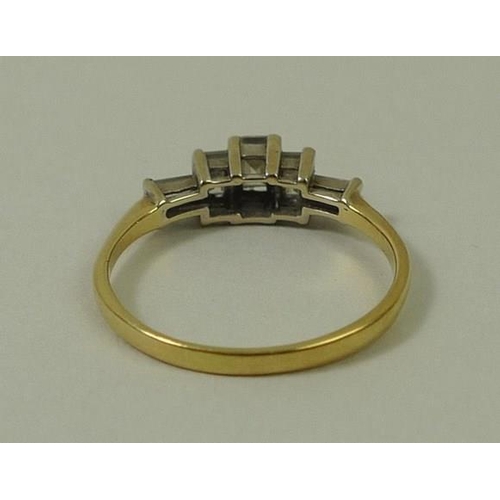 813 - A gold and diamond ring, the central baguette cut diamond flanked by two smaller diamonds, with two ... 