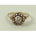 A diamond and gold ring, the central diamond of approximately 0.5ct, surrounded by a circle of twelv... 