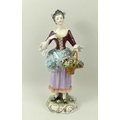 A late 19th century Rudolstadt Volkstedt, Germany, porcelain figurine of a young lady, carrying a ba... 
