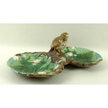 A George Jones majolica hors d'oeuvres dish formed as two polychrome leaf dishes joined by branch wi... 