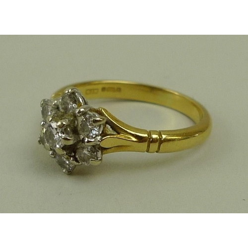 792 - An 18ct gold and diamond ring of flower cluster formation, the central diamond of approximately 0.12... 