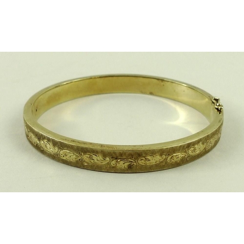 802 - A 14ct gold bangle, with engraved and textured decoration, 15.8g.