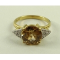 An 18ct gold, diamond and apricot zircon ring, the central peach coloured zircon measuring 8mm diame... 
