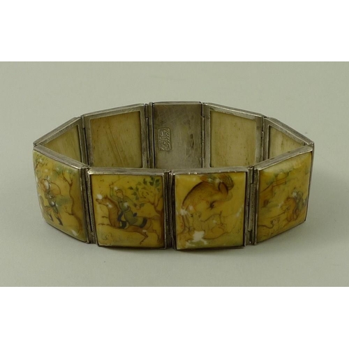 822 - A 19th century South East Asian white metal bangle, set with eight ivory / bone panels, each intrica... 