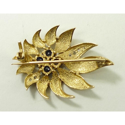 825 - A sapphire and diamond flame flower brooch, with four sapphires to the centre, and two petals set wi... 