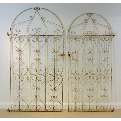 834 - A 20th century wrought iron arched gate, of scrollwork design, with latch, 103 by 192cm, together wi... 