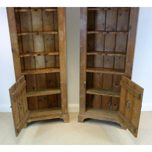 844A - A pair of 19th century pine bookcases, possibly Spanish, each with wide cornice over a domed opening... 