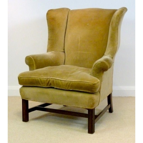 850 - A Georgian style wing armchair upholstered in old gold, 87 by 72 by 105cm high.