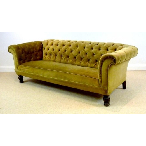 889A - A Victorian mahogany three seater Chesterfield settee, with scroll over arms and turned front legs, ... 