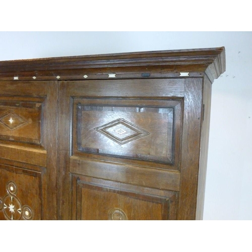 897 - A French 18th century oak cupboard, cornice over two full length doors with carved geometric decorat... 