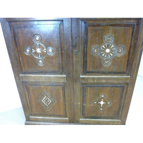 897 - A French 18th century oak cupboard, cornice over two full length doors with carved geometric decorat... 