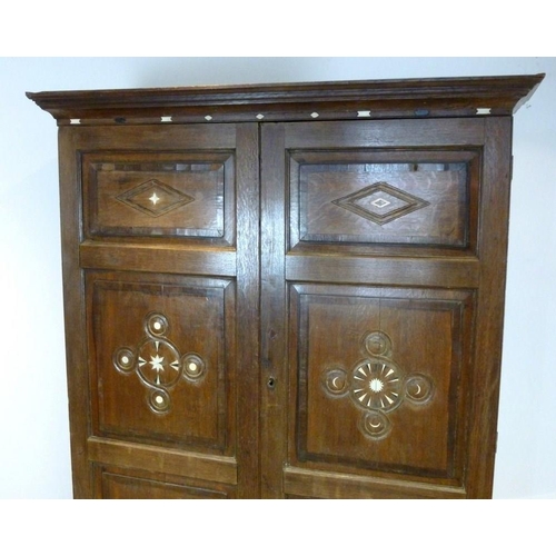 897 - A French 18th century oak cupboard, cornice over two full length doors with carved geometric decorat... 