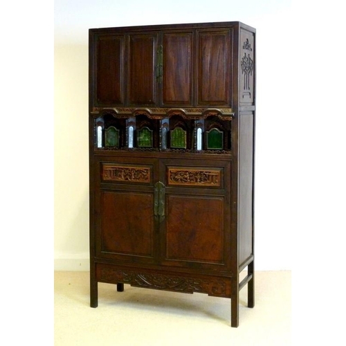 1037 - An early 20th century Chinese carved hardwood cabinet, with two panel doors over a set of four reces... 