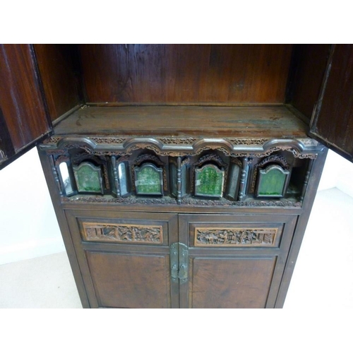 1037 - An early 20th century Chinese carved hardwood cabinet, with two panel doors over a set of four reces... 