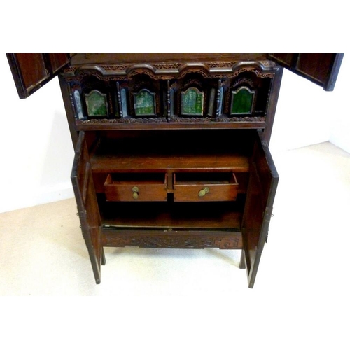 1037 - An early 20th century Chinese carved hardwood cabinet, with two panel doors over a set of four reces... 