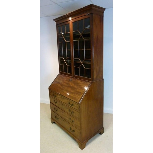 1039 - A George III style mahogany bureau bookcase, circa 1880, the cavetto cornice above a pair of geometr... 