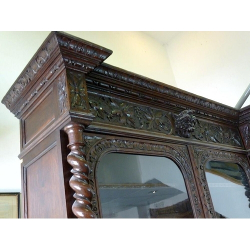 1041 - A 19th century oak bookcase, in the 17th century Dutch style, deeply carved cornice over floral frie... 