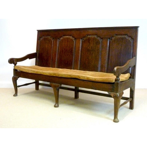 1043 - A mid 18th century provincial oak settle, the rectangular back with four arched fielded panels conti... 