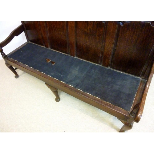 1043 - A mid 18th century provincial oak settle, the rectangular back with four arched fielded panels conti... 