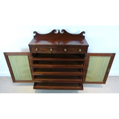 1047 - A Regency mahogany press cupboard, the scroll shaped gallery with brass paterae mounts, over two fri... 