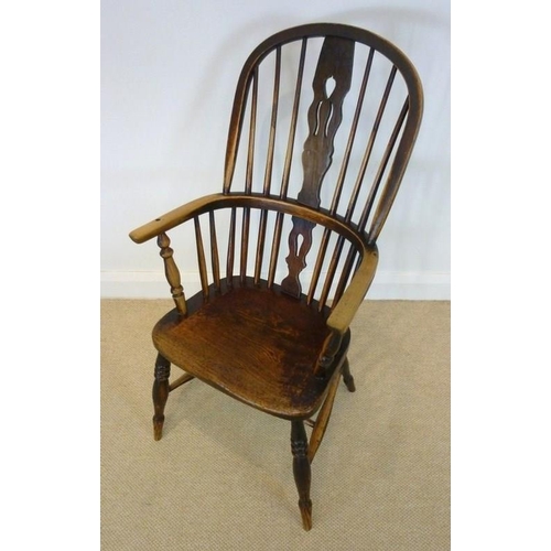 1049 - A 19th century Windsor armchair with solid elm saddle seat, pierced splat, raised on turned legs and... 