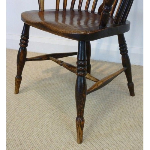 1049 - A 19th century Windsor armchair with solid elm saddle seat, pierced splat, raised on turned legs and... 