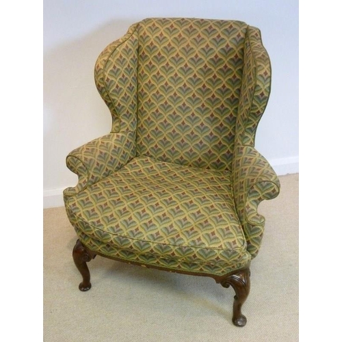 1050 - A George I style walnut framed wing back armchair, circa 1900, with scroll over arms, upholstered in... 