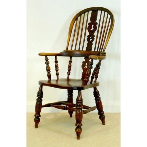 1052 - A late 18th century Windsor armchair with outswept broad arms, a stepped back rail, and pierced and ... 