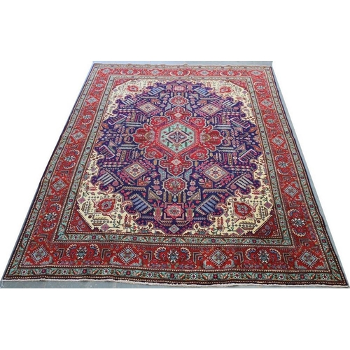 1054A - A Persian carpet with dark blue ground, central red medallion, dense field decorated with various st... 