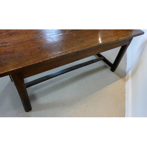 1056 - An early 18th century oak refectory table, the cleated twin plank top above a drawer to one end on s... 