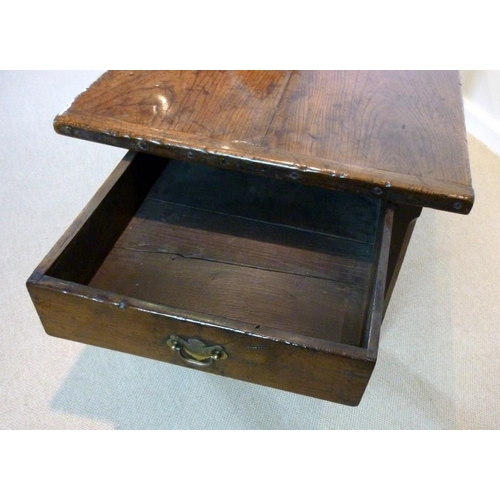 1056 - An early 18th century oak refectory table, the cleated twin plank top above a drawer to one end on s... 