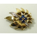 A sapphire and diamond flame flower brooch, with four sapphires to the centre, and two petals set wi... 